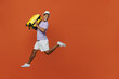 © ViDi Studio - Full body traveler black man wear purple t-shirt hat jump high hold bag look aside isolated on plain orange background Tourist travel abroad in spare time rest getaway Air flight trip journey concept