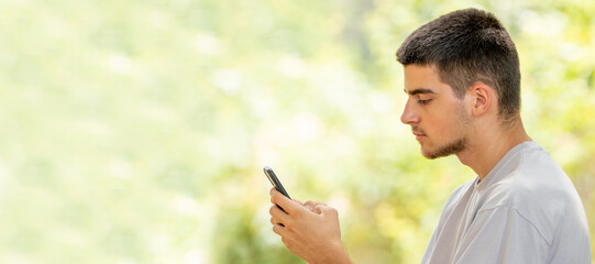 Poster - young man with mobile or cell phone outdoors