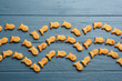 Delicious goldfish crackers on blue wooden table, flat lay