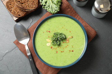 Tasty kale soup served on grey table, flat lay