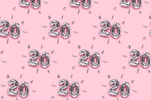 Repetitive Pattern Made Of Number 20 Silver Air Balloons With Ribbons Confetti On A Pink Background. Creative Festive Layout.
