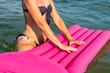 Sexy woman holding pink inflatable mattress in water
