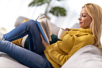 Canvas Print - Woman drinking coffee and reading book at home