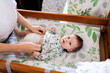 © Austockphoto - Happy baby on change table getting nappy changed ready for the day