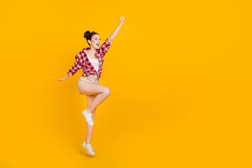 Sticker - Full body portrait of excited energetic girl raise hand look empty space flight isolated on yellow color background