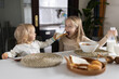 © Алина Бузунова - Cute caucasian siblings sitting at table on kitchen early morning and preparing breakfast with colorful cornflakes and milk. Kids enjoying life with healthful food, healthy lifestyle concept