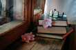 cute cozy books with flowers on an old wooden windowsill