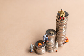 Wall Mural - Miniature people Mountain climber ascending the coin stack