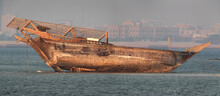 A Boat On The River Bed During Low Tide, Anchored At Sea Shore Of Arad, Bahrain