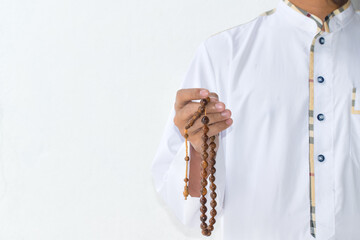 Wall Mural - Religious muslim islam man in white session lift hand for praying and wearing bead on hand to determine the number of prayer services.concept for Ramadan, Eid al Fitr, eid ad-ha, meditation, praying