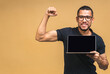 © denis_vermenko - Young smiling african american black man standing and using laptop computer isolated over beige background. Showing pc screen.