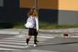 schoolgirl crosses the road at a pedestrian crossing

