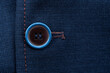 A row of buttons on the sleeve of a blue men's suit. clothing element