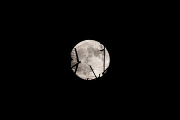 Wall Mural - Full moon at night. The moon passes behind the television antenna in the foreground.