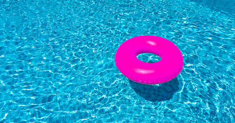 Wall Mural - Pink ring floating in blue swimming pool. Inflatable ring, rest concept