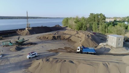 Poster - Use of heavy equipment in construction industry. Scene. Truck moves at a construction site covered with sand and gravel.