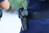 Pistolet w kaburze na pasie policjanta patrolowego. 