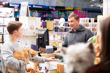 Pet Store Visitors With Dogs Buy Food And Other Products For Their Pets
