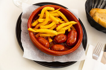 Popular Spanish tapa originally from Asturias of smoked chorizo cooked in cider with garnish of fried potatoes