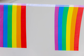 Celebration of pride month, Waving small colourful flags hanging on the rope with blue sky, The rainbow flag is a symbol of lesbian, gay, bisexual, transgender and queer, World LGBTQ social movements.