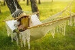 Woman with hat resting in comfortable hammock at green garden.