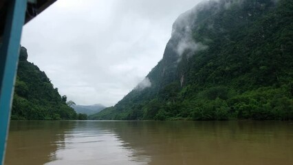 Wall Mural - Slow motion of a boat sailing in the Ou river with mountain views on foggy day