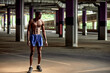 © Georgii - Handsome afro American sportman standing on the street while taking break after training. Black male having rest after workout