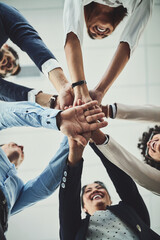 Hands stacked and piled showing team unity, strength or motivation among creative business colleagues from below. Excited, laughing and huddled group of inspired business people ready for success