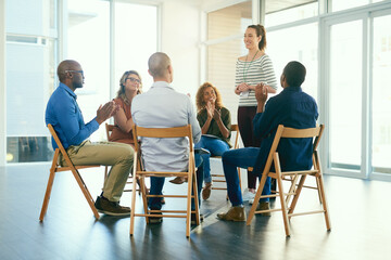Poster - Business woman coaching a teamwork seminar at work about job motivation and success. Group of office workers clapping hands after a team presentation. Smiling colleagues sitting together in a meeting