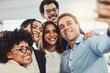 © Nola Viglietti/peopleimages.com - Happy, diverse and carefree colleagues taking a selfie to share on social media on their break. An excited young group of employees having fun at the office taking a picture or photo