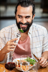 Canvas Print - food, eating and people concept - happy smiling man with beard having dinner at restaurant