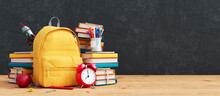 Yellow School Bag With Books And Accessory On Empty Black Chalkboard. Back To School Concept Background 3D Rendering, 3D Illustration	