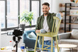 © Syda Productions - blogging, furniture restoration and home improvement concept - happy smiling man or blogger with camera showing old wooden chair renovation and recording tutorial video