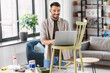 © Syda Productions - furniture restoration, diy and home improvement concept - happy smiling man with laptop preparing old wooden chair for renovation