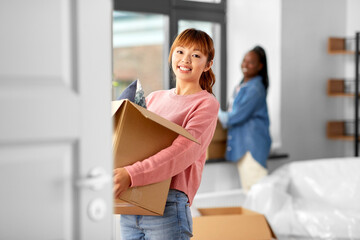 Wall Mural - moving, people and real estate concept - happy smiling women with boxes at new home