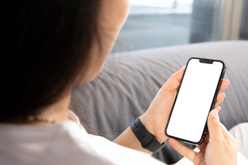 holding smart phone, young woman sitting on sofa and holding smart phone with mockup white blank dis