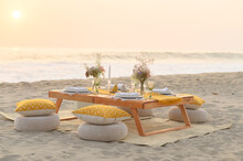 Small Wooden Decorated Table Placed On Sandy Seashore Before Romantic Dinner