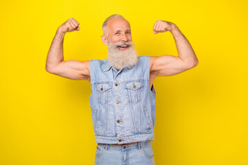 Sticker - Photo of strong cool retired guy wear jeans waistcoat smiling rising fists showing arm muscles isolated yellow color background