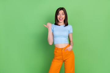 Wall Mural - Photo of young attractive gorgeous nice woman unbelievable sale pointing empty space isolated on green color background