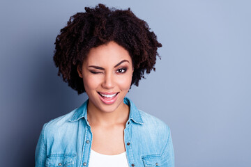 Poster - Photo of adorable cheerful lady beaming smile eye wink empty space isolated on grey color background