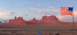 American National Flag Overlay. Scenic Road in the Dry Desert with Red Rocky Mountains in Background. Sunrise Sky. Forrest Gump Point in Oljato-Monument Valley, Utah, United States. Panorama