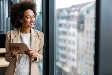 Sticker - Happy business woman manager holding tablet and working in modern office