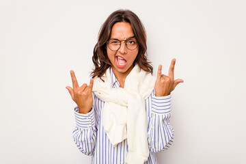 Wall Mural - Young hispanic woman isolated on white background showing a horns gesture as a revolution concept.