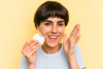 Wall Mural - Young caucasian woman holding teeth whitener isolated on yellow background