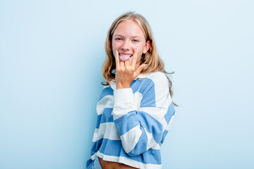 Caucasian teen girl isolated on blue background showing rock gesture with fingers