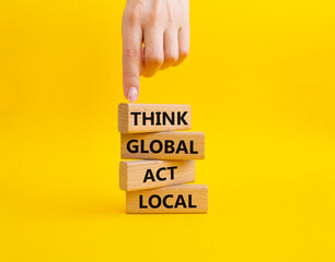 Think global act local symbol. Wooden blocks with words Think global act local. Beautiful yellow background. Businessman hand. Business and Think global act local concept. Copy space.
