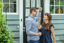 A Woman Holding Up The House Key To Their New Home In This Fast Paced Real Estate Market