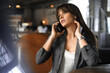 © Stavros - Young businesswoman talking on the phone during a coffee break.