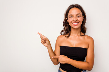 Poster - Young hispanic woman isolated on white background excited pointing with forefingers away.