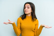 Young caucasian woman isolated on blue background doubting and shrugging shoulders in questioning gesture.